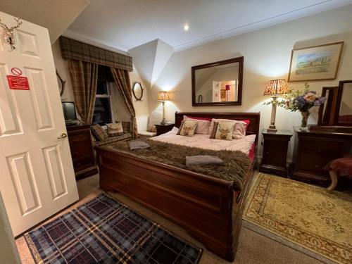 格拉斯哥West Highland Way Hotel的一间卧室配有一张大床和镜子