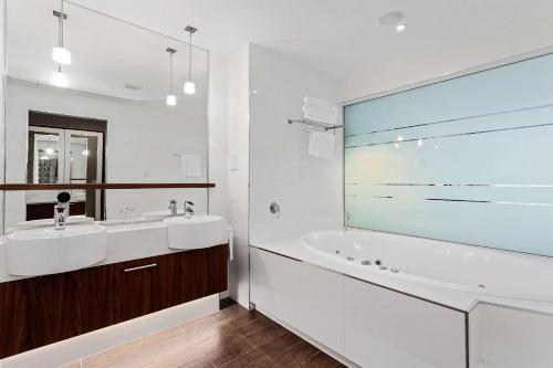 Taylors Lakes泰勒湖品质酒店的白色的浴室设有浴缸、水槽和浴缸。