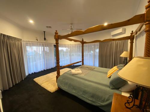 金斯科特多莱斯湾旅馆的一间卧室设有一张天蓬床和大窗户