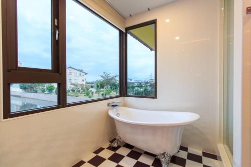 五结风清雅筑的带浴缸的浴室,带窗户
