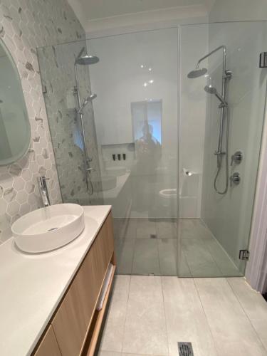 金斯科特多莱斯湾旅馆的一间带玻璃淋浴和水槽的浴室