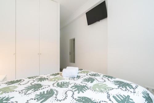 波尔图Moreira Terrace的一间卧室配有一张带绿色和白色棉被的床
