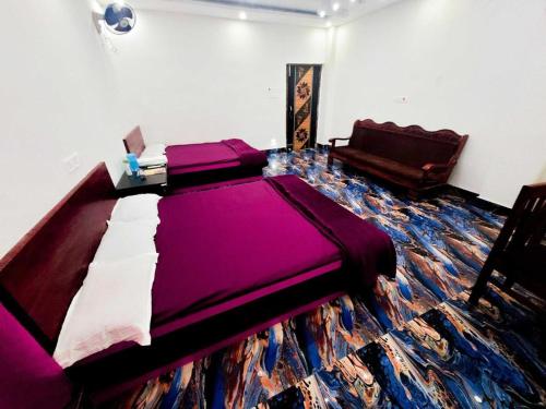 德奥加尔Parinay Vatika Inn的一间卧室配有一张大紫色的床和一张沙发