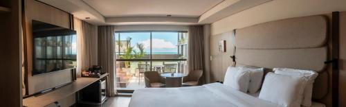 若昂佩索阿HCM - Hotel Corais de Manaira的酒店客房设有一张床,享有海景。