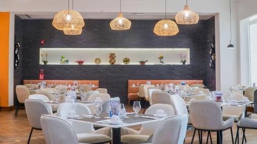 巴拿马城巴拿马市中心希尔顿花园酒店的用餐室配有白色的桌椅和灯光
