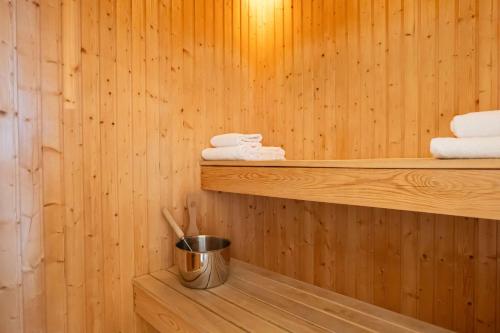 索尔纳索尔纳丽笙公园酒店的一个带毛巾和架子上桶的桑拿浴室