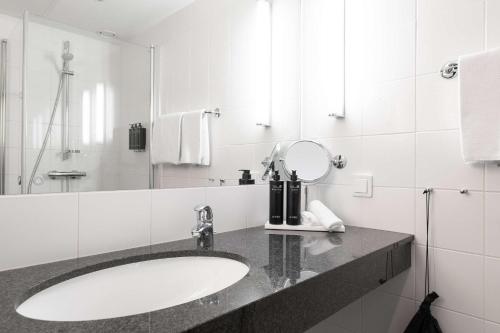 隆德Best Western Plus Park City Lund的白色的浴室设有水槽和镜子
