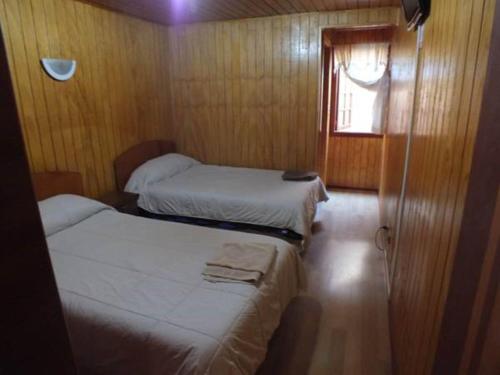 蒙特港Hostal Lagunitas的小型客房 - 带2张床和窗户