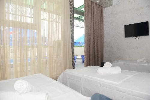 巴统Emilia的酒店客房设有两张床和电视。