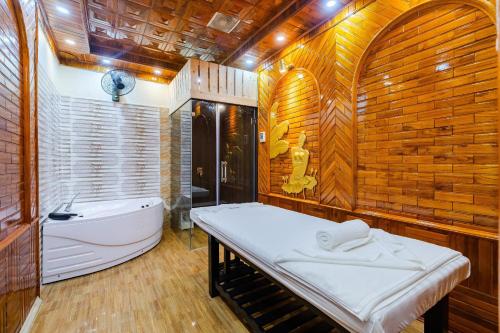 Sóc SơnNoi Bai The King Hotel的一间带一张床和浴缸的浴室