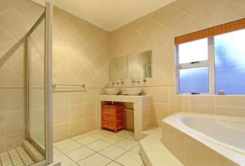 布鲁堡史特兰Durham Close 31 by HostAgents的带浴缸、水槽和镜子的浴室