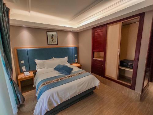杜阿拉Hotel Royal Palace的一间卧室配有一张大床和蓝色床头板