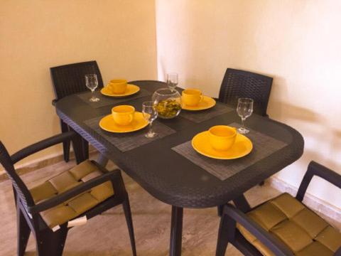 丹吉尔NOUVEAU, Residence Cap Spartel avec une vue sur mer的一张黑色桌子,上面有黄色的板子和玻璃杯