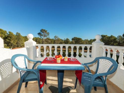 迈阿密普拉特亚Holiday Home Blanca by Interhome的阳台上的桌子,两把椅子和一张鲜花桌子