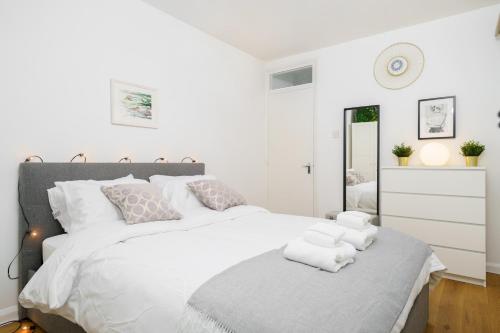 伦敦Lovely Apartment in Victoria Park Village的卧室配有带毛巾的大型白色床