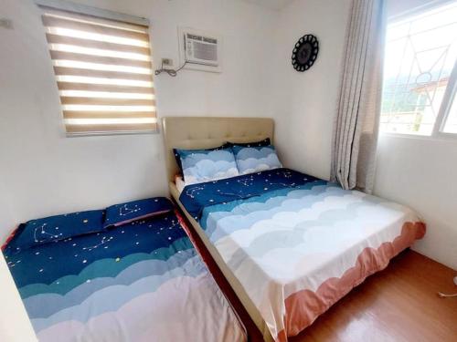 苏比克Cozy Corner at Camella Subic Vista Estates的一间带两张床的卧室,位于带窗户的房间内