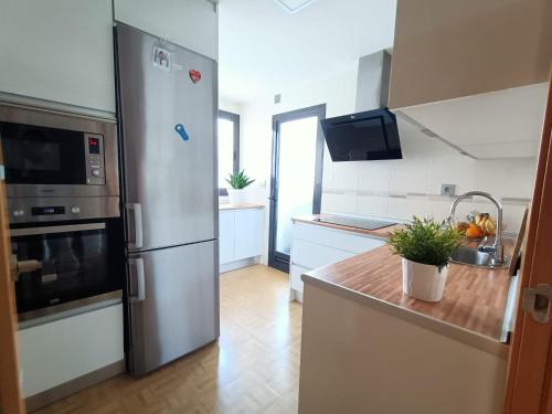 格拉纳达Acogedora habitación privada en Villa Mayka的厨房配有不锈钢冰箱和白色橱柜
