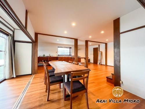 妙高Arai Villa Myoko的一间带木桌和椅子的用餐室