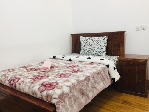 努沃勒埃利耶赫格斯特乡村简易别墅的一间卧室配有一张带花卉床罩的床