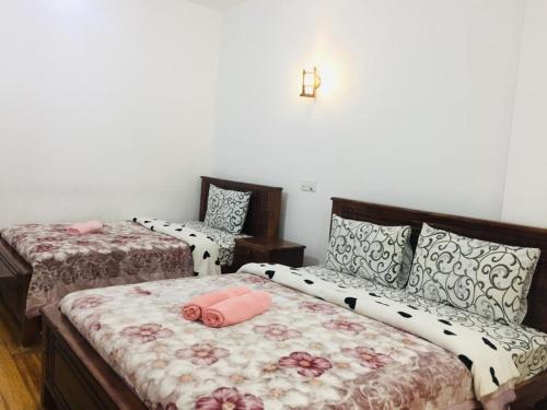 努沃勒埃利耶赫格斯特乡村简易别墅的一间卧室配有两张带粉红色枕头的床