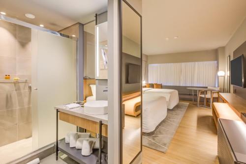 阿雷格里港DoubleTree by Hilton Porto Alegre的酒店客房设有浴室和卧室