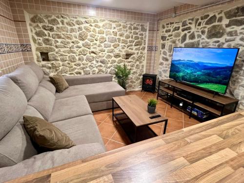 Villar de HuergoLa Casina de Villar的带沙发和平面电视的客厅