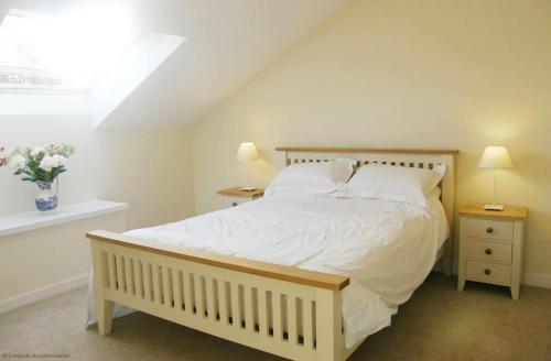 奥尔顿Maplescombe的一间卧室配有一张带2个床头柜的大型白色床