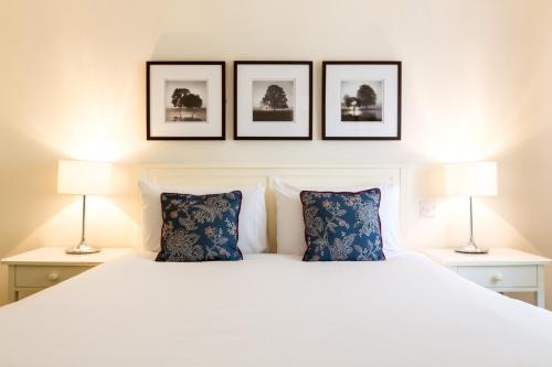 凯尼尔沃思Abbey Fields By Chef & Brewer Collection的卧室配有一张白色床,墙上挂有三张照片