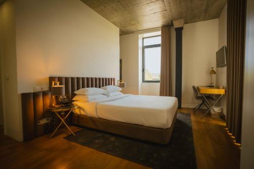 维拉·雷阿尔Borralha Hotel, Restaurante & Spa的一间卧室设有一张大床和一个窗户。