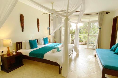 恩德培Karibu Entebbe的一间卧室配有一张带天蓬的床