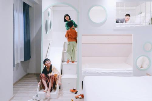 新加坡Rest Bugis Hotel的两个女孩坐在双层床的楼梯上