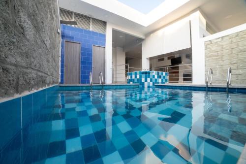 圣玛尔塔Hotel Santa Marta Tropical的拥有蓝色瓷砖的游泳池和天花板。