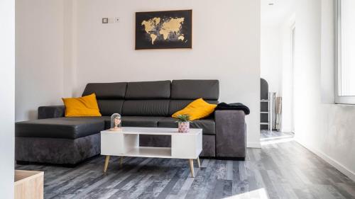 普瓦捷Le Modernisme - Joli T3 lumineux pour 4 pers的客厅配有黑色沙发和黄色枕头