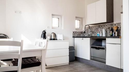 普瓦捷Le Modernisme - Joli T3 lumineux pour 4 pers的白色的厨房配有白色的橱柜和桌子