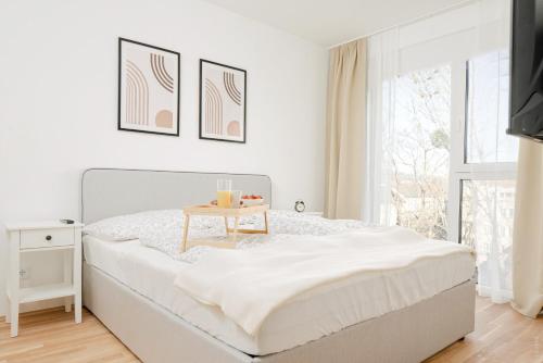 格拉茨Oidahome - Apartment am Hauptbahnhof - contactless Self-Check-IN的白色卧室配有一张桌子和一张床铺