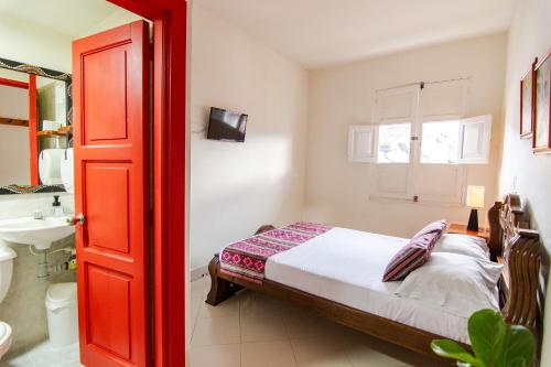 贾丁Hotel Casa Grande的一间卧室配有床、水槽和红色的门