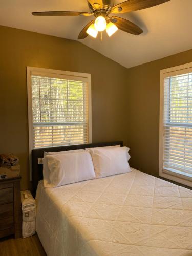 西点Louisiana State Cabin的一间卧室配有一张带吊扇的床和2扇窗户。