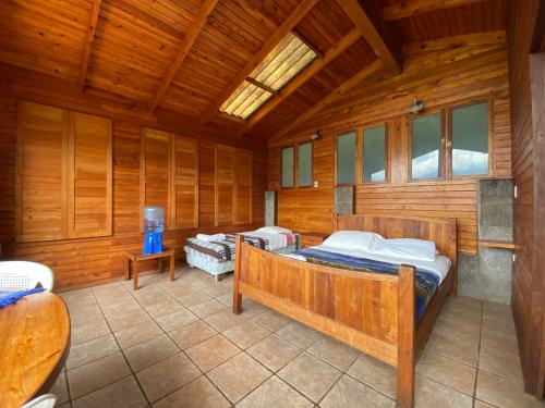 圣胡安拉拉古纳Lakefront Chalet的木制客房内的一间卧室配有两张床