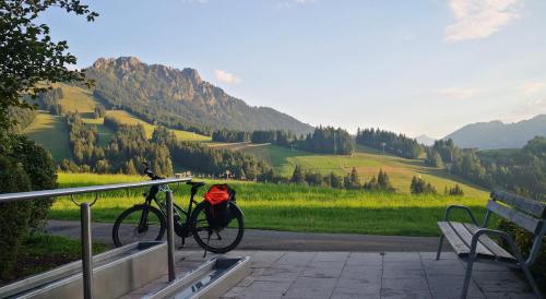 容霍尔茨Jungholz Erlebnis的一辆自行车停在长凳边,背着背包