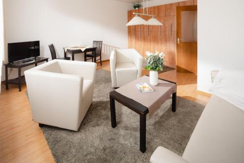 诺德奈Haus Meeresblick Wohnung 2的客厅配有两把椅子和一张桌子