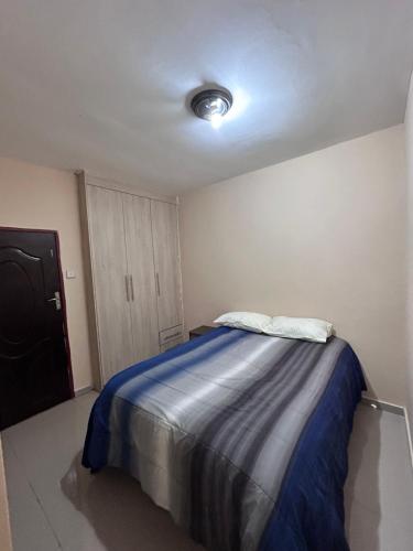 卢萨卡Tranquil Room in Apartment的一间卧室配有一张带蓝色毯子的床