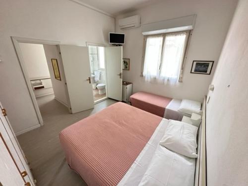 米兰马瑞提那Hotel Fiorenza的一间带两张床的卧室和一间带窗户的房间