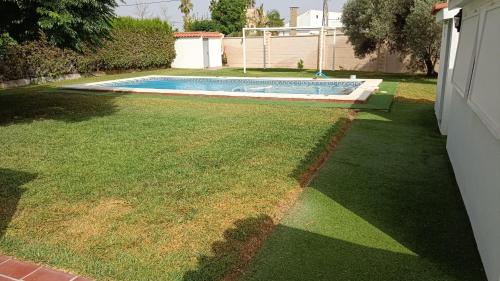 埃斯帕尔蒂纳斯Montaraz 1 Espartinas的后院设有游泳池和草地庭院