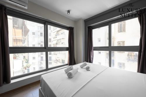 塞萨洛尼基WeStay Apartments, The Luxury Suites的卧室配有白色的床和大窗户