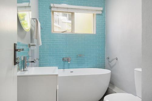 巴利托Kingston Estate 112 by HostAgents的浴室设有水槽、卫生间和蓝色瓷砖。