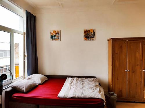 布鲁塞尔Studio entier avec balcon - Tour et Taxis的带红色床和窗户的房间