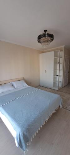 TürkistanОднокомнатная квартира в административном центре的一间卧室配有一张带蓝色毯子的床