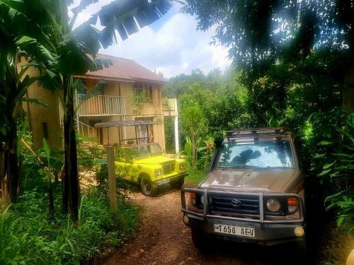 阿鲁沙Holiday cottage by the river, Arusha的停在房子前面的黄色吉普车