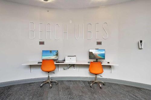 代托纳海滩1 BR Resort Condo Direct Oceanfront Wyndham Ocean Walk - Daytona Funland 1307的一个带两张桌子和两张橙色椅子的办公室
