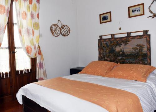 埃拉蒂特里卡隆ΛΑΓΟΥΜΙ suite Α1的一间卧室配有一张带橙色棉被的床